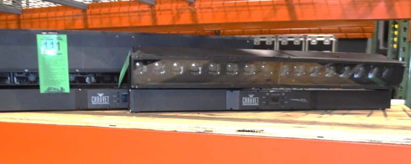 Two Chauvet DJ lighting units on a shelf with a green tag labeled "111".