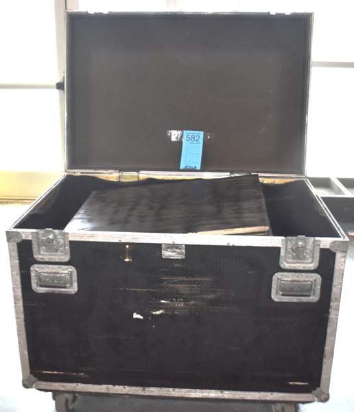 Open black storage case with a large black object inside and a blue tag labeled "582".