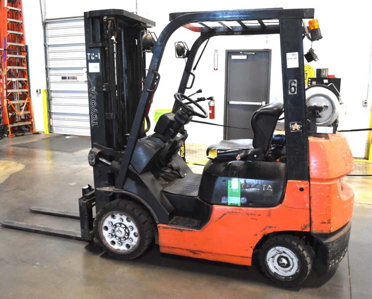 Red and black Toyota forklift parked indoors.